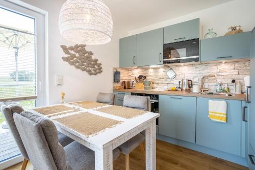 a kitchen with a table and chairs in a room at Seaside Corner Tossens - Seaside Corner Tossens - Komfort, Ruhe und Nachhaltigkeit in Butjadingen OT Tossens