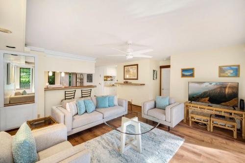 a living room with two couches and a tv at Waikomo Stream 402 in Koloa