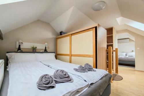 a bedroom with a bed with towels on it at Appartamento Quattroporte in Budapest
