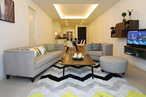 a living room with a couch and a table and a tv at The Shore Hotel & Residences in Melaka
