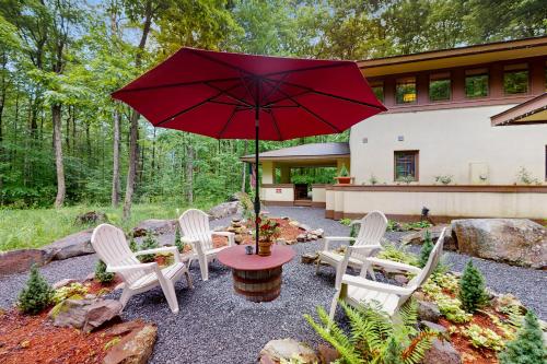 a patio with a table and chairs and a red umbrella at The Frank Lloyd Wright Home @ Deep Creek, MD in Bittinger