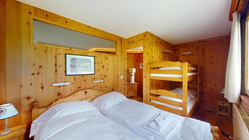 a bedroom with a bed and two bunk beds at Abitaziun Chüderas 12 in La Punt-Chamues-ch