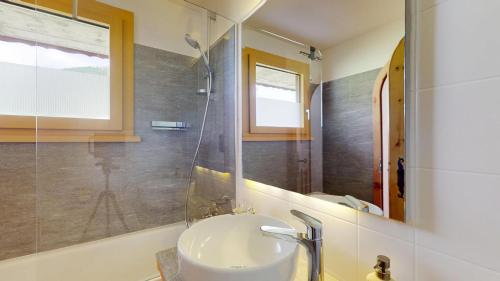a bathroom with a sink and a mirror at Abitaziun Chüderas 12 in La Punt-Chamues-ch