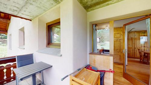 a room with a bench and a table and a window at Abitaziun Chüderas 12 in La Punt-Chamues-ch