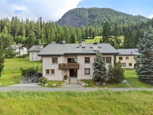 a large white house with a mountain in the background at Abitaziun Chüderas 12 in La Punt-Chamues-ch