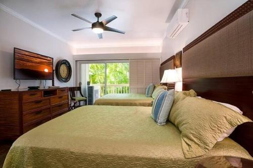 a bedroom with two beds and a ceiling fan at Regency 311 in Kipu