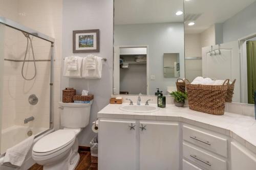a white bathroom with a toilet and a sink at Regency 311 in Kipu
