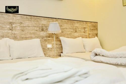 a bed with white sheets and a lamp in a room at Comfort in Cairo