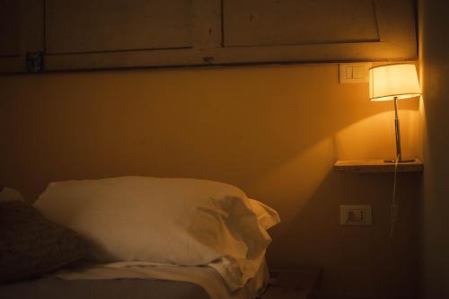 a dark room with a bed and a lamp at 4 Balconi rooms-Boutique B&B in Lecce