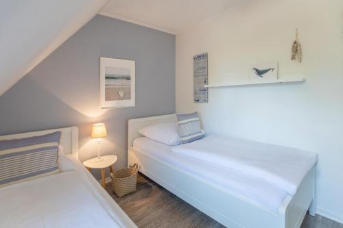 a small bedroom with two beds and a lamp at Wellenklang in Böhl