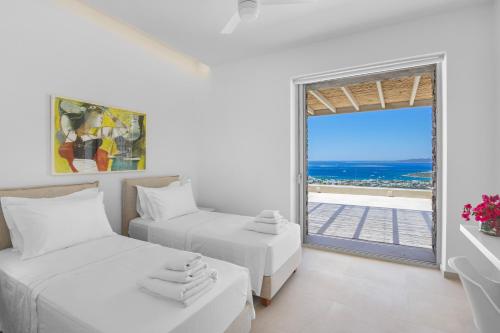 two beds in a room with a view of the ocean at Pasithea Horizon in Kampos Paros