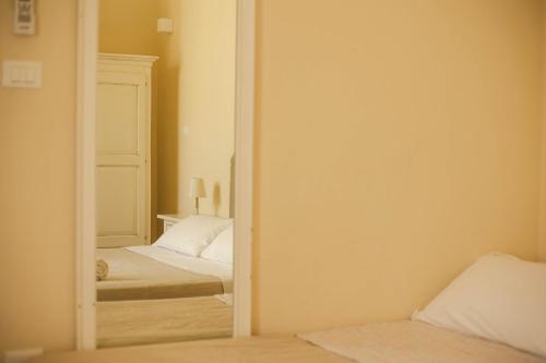 a bedroom with two beds and a mirror at 4 Balconi rooms-Boutique B&B in Lecce