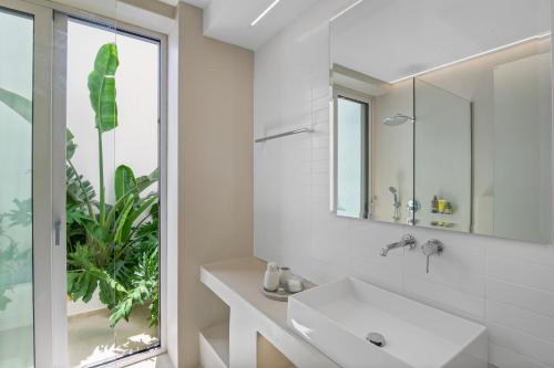 a white bathroom with a sink and a mirror at Pasithea Horizon in Kampos Paros