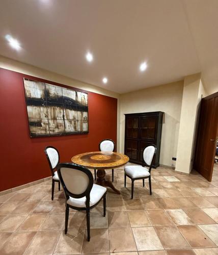 a dining room with a table and chairs and red wall at Cadorna36 in Locri