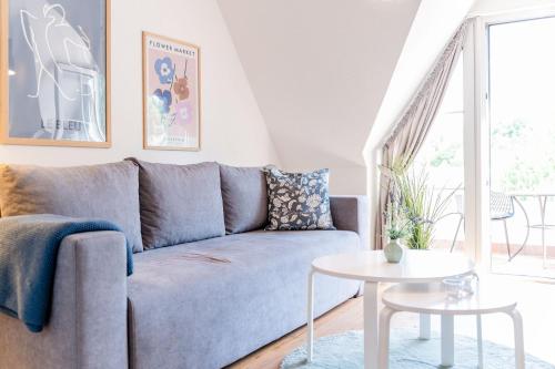 a living room with a blue couch and a table at Ostsee, wunderschöne Wohnung mit Meerblick in Harrislee