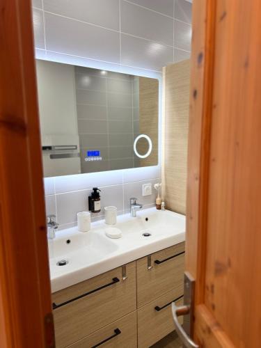 a bathroom with a sink and a large mirror at Maison des Passeroses in Boutiers-Saint-Trojan