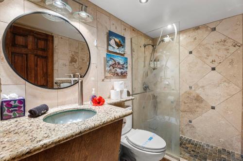Un baño con lavabo, inodoro y espejo. en Kona Reef A6, en Kailua-Kona
