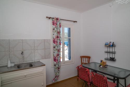 コッカリにあるKokkari Sea View Traditional Greek Homeの窓、テーブル付きのキッチンが備わります。