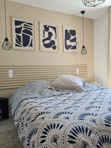 - une chambre avec un lit et 4 photos sur le mur dans l'établissement Baradozic le petit paradis à Melon, à Porspoder