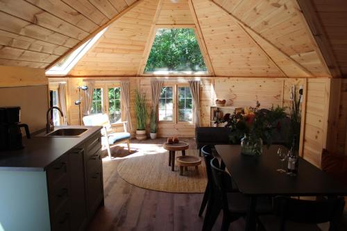 a kitchen and living room of a tiny house at Prachtige 4p wellness Kota in bos met Sauna en Hottub in Diever