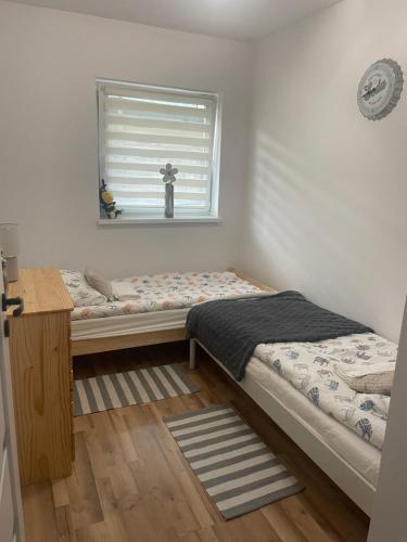 a bedroom with two beds and a window at Apartamenty Paradise in Tupadła