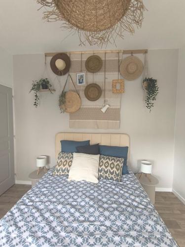 - une chambre avec un lit et quelques chapeaux sur le mur dans l'établissement Brise Nacrée proche plage, à Dunkerque