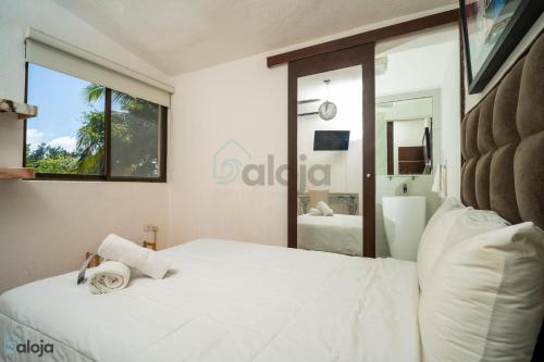 a bedroom with a large white bed and a bathroom at Hotel Boutique Maraf Cancun in Cancún