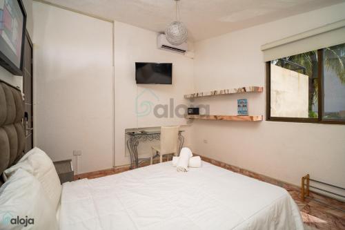 a bedroom with a white bed and a television at Hotel Boutique Maraf Cancun in Cancún