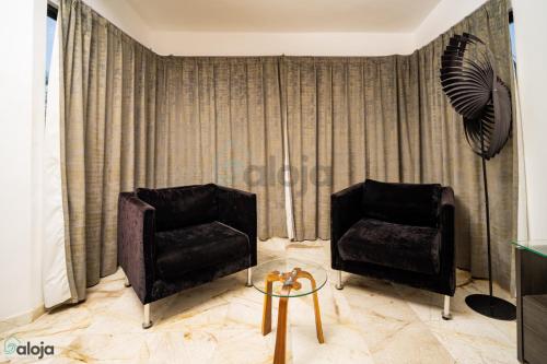 a living room with two chairs and a fan at Hotel Boutique Maraf Cancun in Cancún