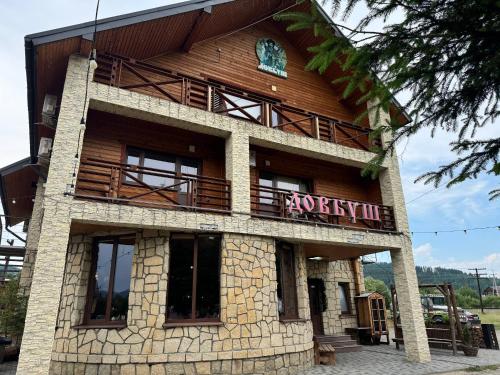 a building with a sign on the side of it at Готель Довбуш in Yaremche