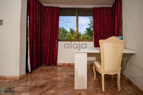 a table and a chair in a room with a window at Hotel Boutique Maraf Cancun in Cancún
