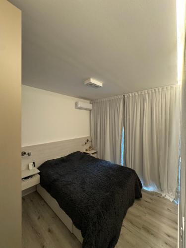 Un dormitorio con una cama negra y una ventana. en Belgrano Pro housing, en Morteros