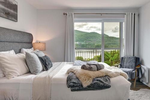 a bedroom with a bed and a window with a view at Magnifique VUE LAC et SKI in Mont-Tremblant