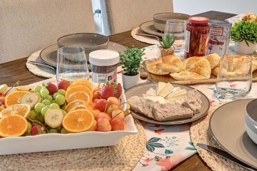 a table topped with a plate of fruit and bread at Magnifique VUE LAC et SKI in Mont-Tremblant