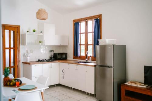 a kitchen with white cabinets and a stainless steel refrigerator at Sueño Caribeño in La Laguna
