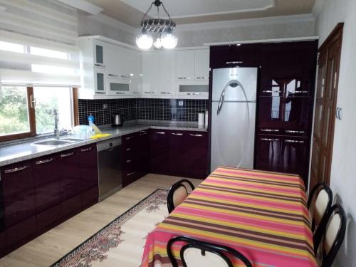 a kitchen with a table and a refrigerator at Trabzon Gürbulakta kiralık villa in Trabzon