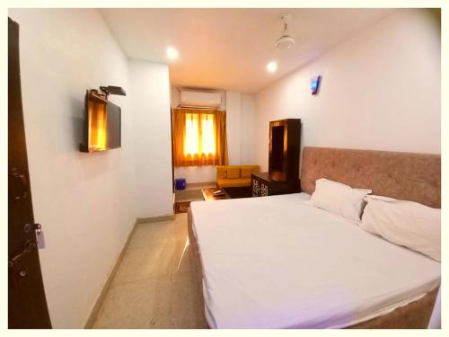 a bedroom with a white bed and a window at LUCKNOW HOTEL METRO REGENCY - Near Railway Station And Temple -#Free Wi-Fi #Restrurant #Parking Facilities # Fully Air-Condition- A Premium Hotel In Lucknow in Lucknow