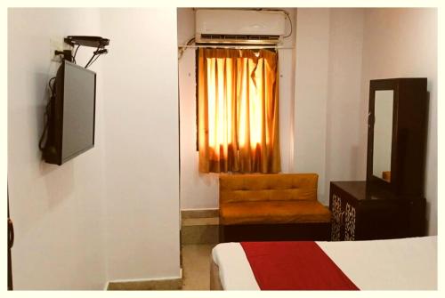 a room with a bed and a television and a chair at LUCKNOW HOTEL METRO REGENCY - Near Railway Station And Temple -#Free Wi-Fi #Restrurant #Parking Facilities # Fully Air-Condition- A Premium Hotel In Lucknow in Lucknow