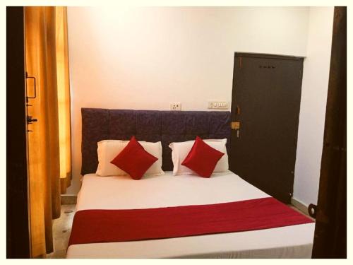 a bedroom with a bed with red and white pillows at LUCKNOW HOTEL METRO REGENCY - Near Railway Station And Temple -#Free Wi-Fi #Restrurant #Parking Facilities # Fully Air-Condition- A Premium Hotel In Lucknow in Lucknow