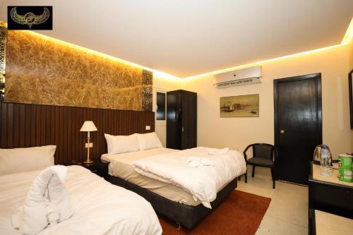 a hotel room with two beds and a chair at Comfort in Cairo