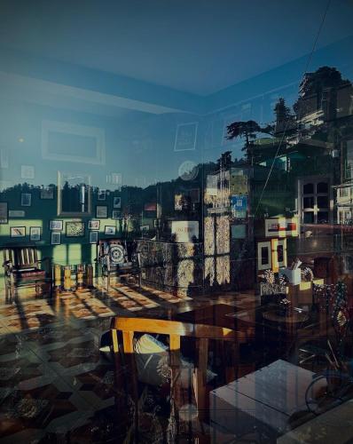a view of a city from a window with a bench at ZuZu - A Travellers Hostel in Shimla