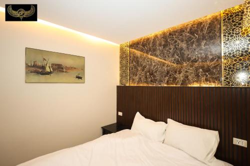 a bedroom with a bed and a painting on the wall at Comfort in Cairo