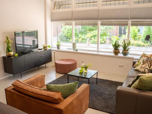 a living room with a couch and a tv at Boetiek SimonS Loft appartement centrum Brummen in Brummen