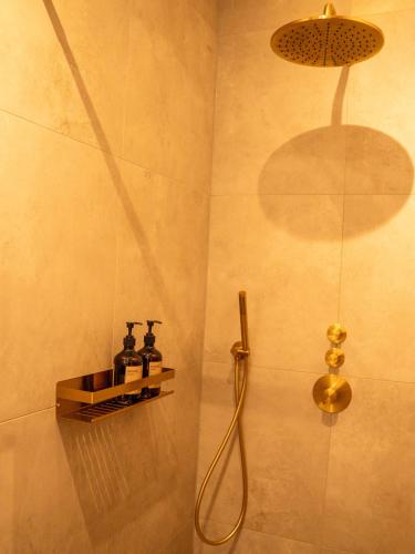a bathroom with a shower with a shower head at Boetiek SimonS Loft appartement centrum Brummen in Brummen