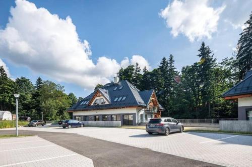 a house with a car parked in a parking lot at Luxury 2 Bedroom Mountain Escape in Harrachov