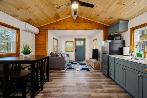 a kitchen and living room with a table and refrigerator at Arbutus Lake Cozy Cabin-Pontoon Rentals Available in Traverse City