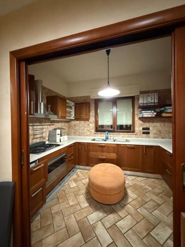 a kitchen with a stool in the middle of a room at Cadorna36 in Locri