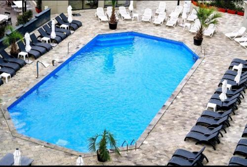 een groot zwembad met ligstoelen en een zwembad bij Alezzi beach luxury Lidia apartment in Mamaia Nord – Năvodari