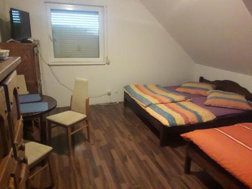 a bedroom with a bed and a chair and a window at Pokoje gościnne Ania in Mikoszewo