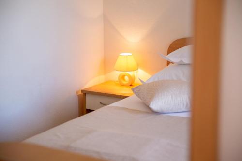 a bedroom with a bed and a lamp on a night stand at Villa Alesa Steva in Tučepi